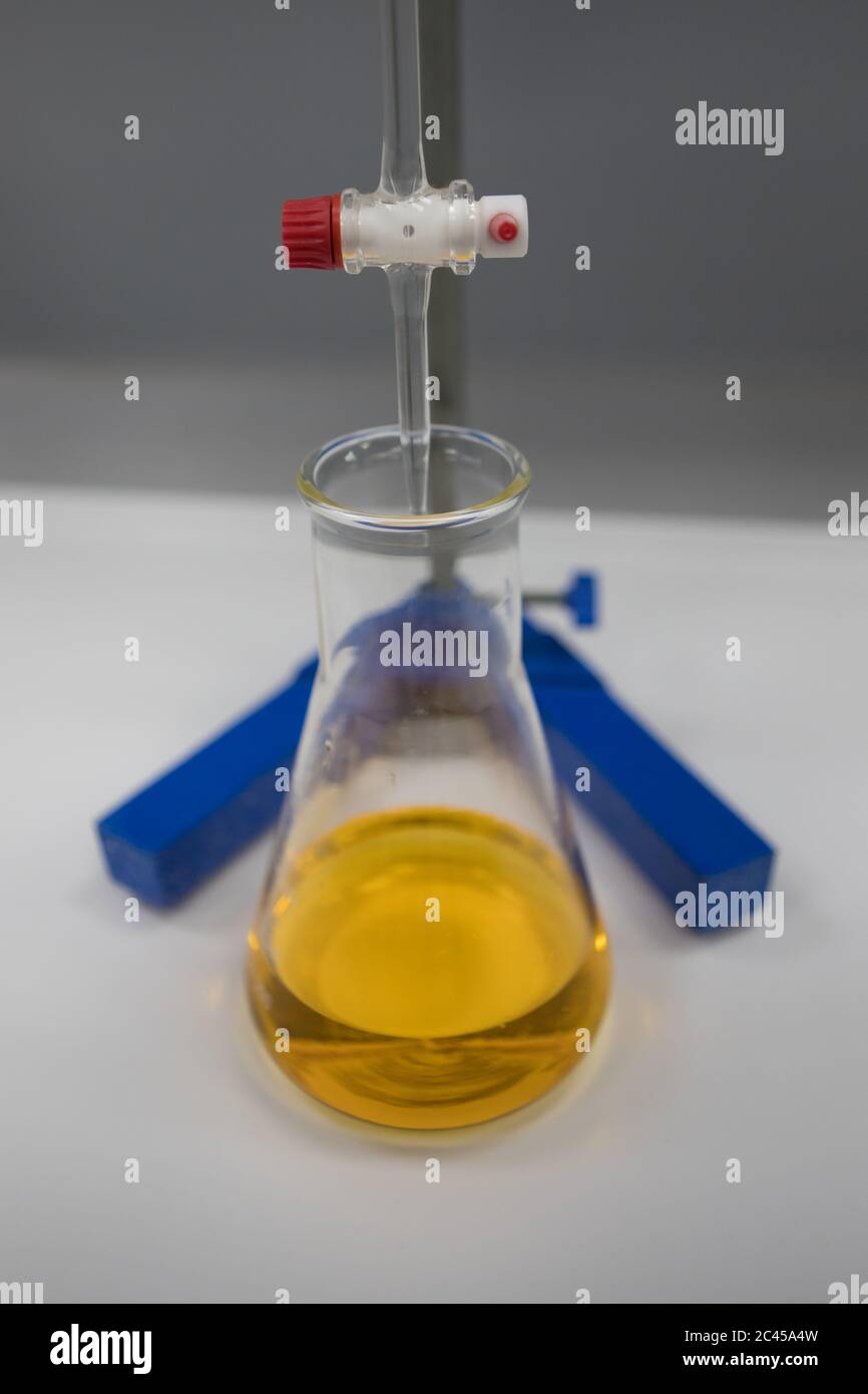 Titration einer Lösung mit einem orangefarbenen Indikator. Chemiker in einem pharmazeutischen Labor Stockfoto