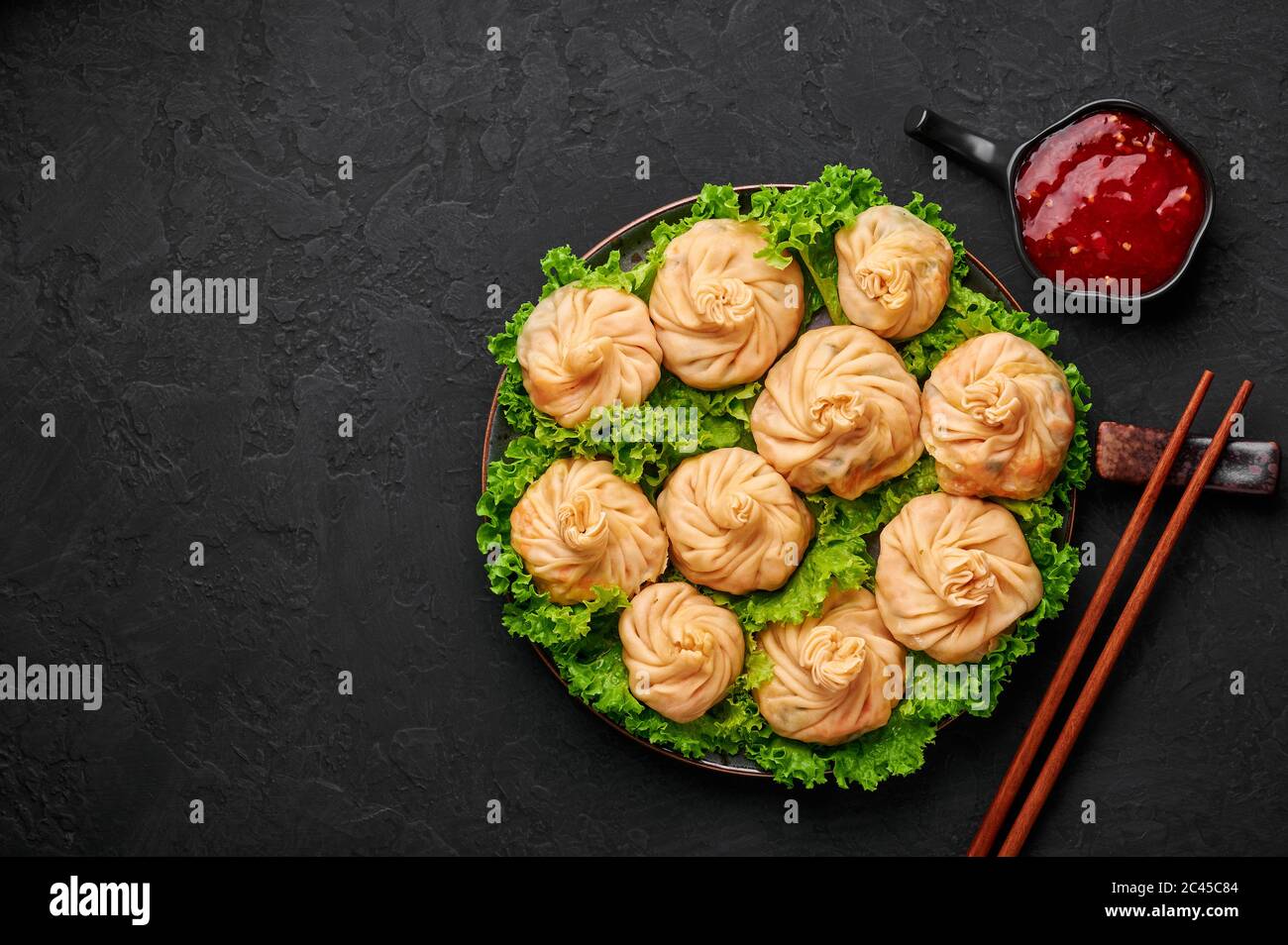 Veg Momos auf schwarzer Schieferplatte. Momos ist das beliebte Gericht der indischen, tibetischen, chinesischen Küche. Asiatische Küche. Vegetarisches Menü. Speicherplatz kopieren. Draufsicht Stockfoto