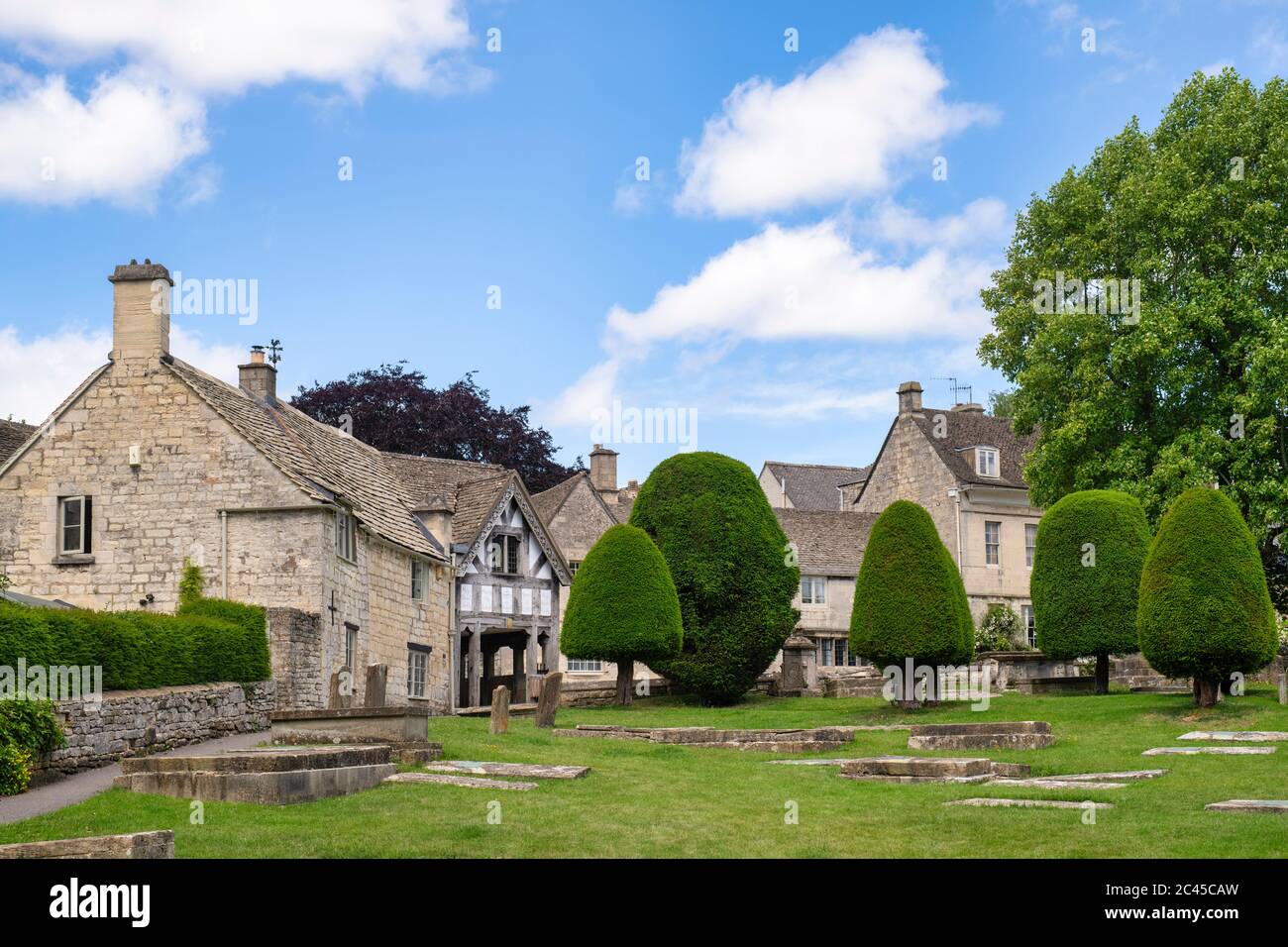 St Marys Kirche lychgate und Eibenbäume im Sonnenlicht. Painswick, Cotswolds, Gloucestershire, England Stockfoto