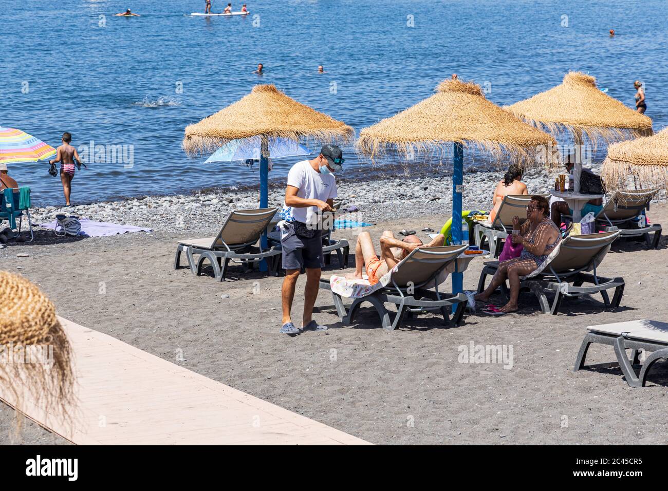 Sonnenbaden und Entspannen am Strand an einem sonnigen Tag im Juni, Playa San Juan, Teneriffa, Kanarische Inseln, Spanien Stockfoto