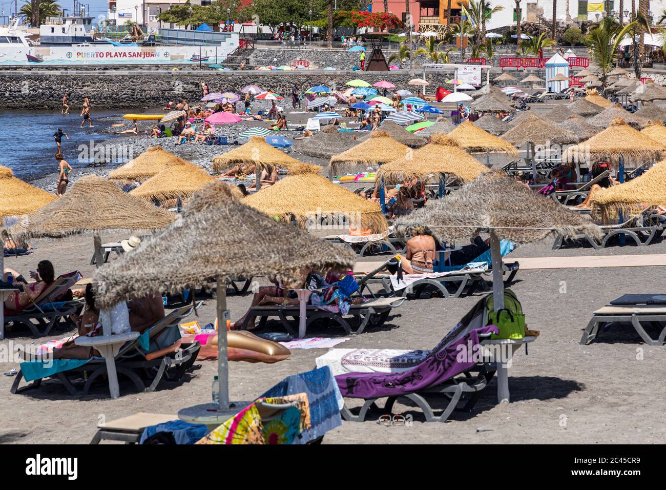 Sonnenbaden und Entspannen am Strand an einem sonnigen Tag im Juni, Playa San Juan, Teneriffa, Kanarische Inseln, Spanien Stockfoto
