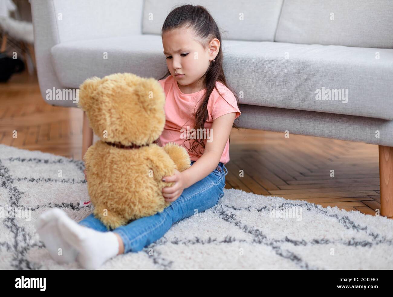 Deprimiert Kind Mädchen Holding Teddybär Allein Sitzen Zu Hause Stockfoto