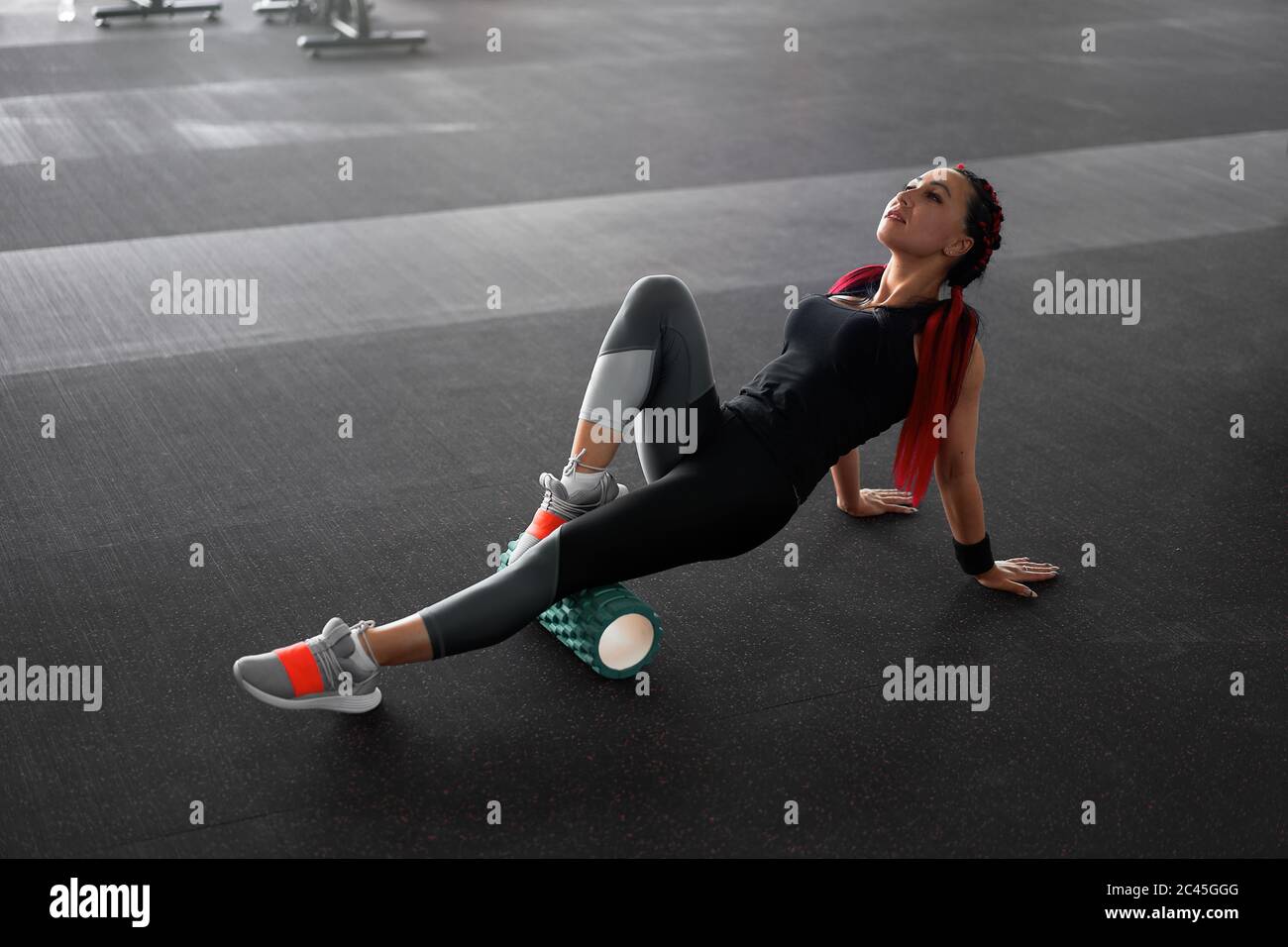 Frau massieren Schaum Roll Bein Gym myofascial Release Übung Rollen, Trigger-Punkte mittlere Erwachsene kaukasischen Frau Sportlerin nutzt Roller-Massagegerät für Entspannung, Dehnung der Muskeln und Rückenschmerzen. Stockfoto