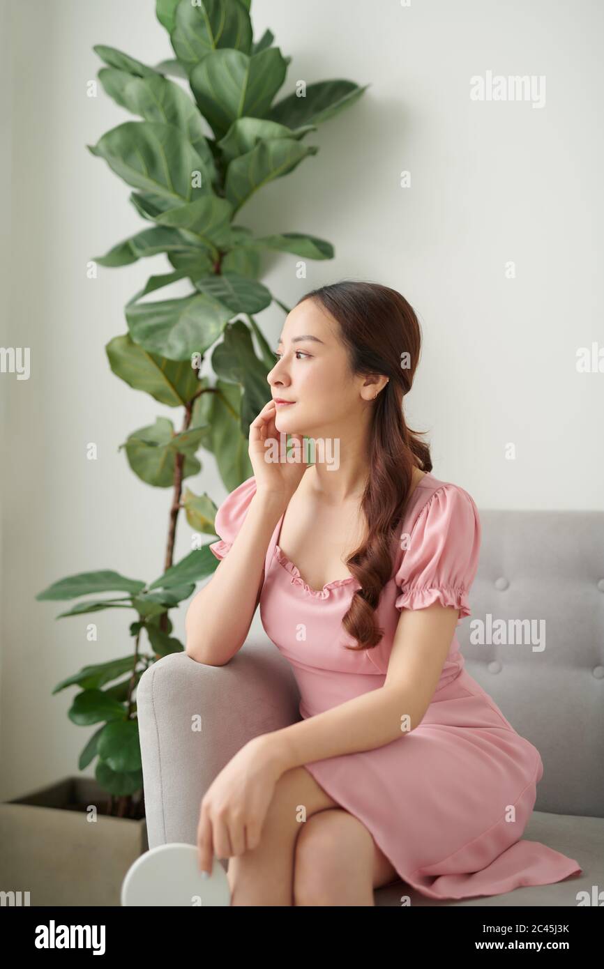 Schöne asiatische Frau zu Hause auf Couch entspannen, genießen Freizeit. Stockfoto