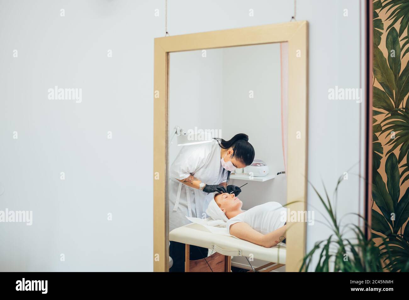 Spiegelbild der Frau, die ihre Augenbrauen in einem Schönheitssalon gemacht. Stockfoto