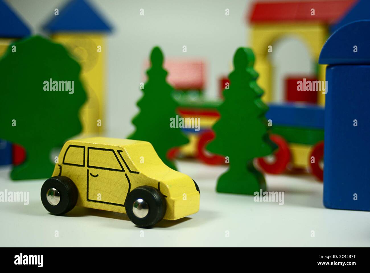 Holzauto vor Ihrer kleinen Stadt Kulisse aus Holz als Kinderspielzeug Stockfoto
