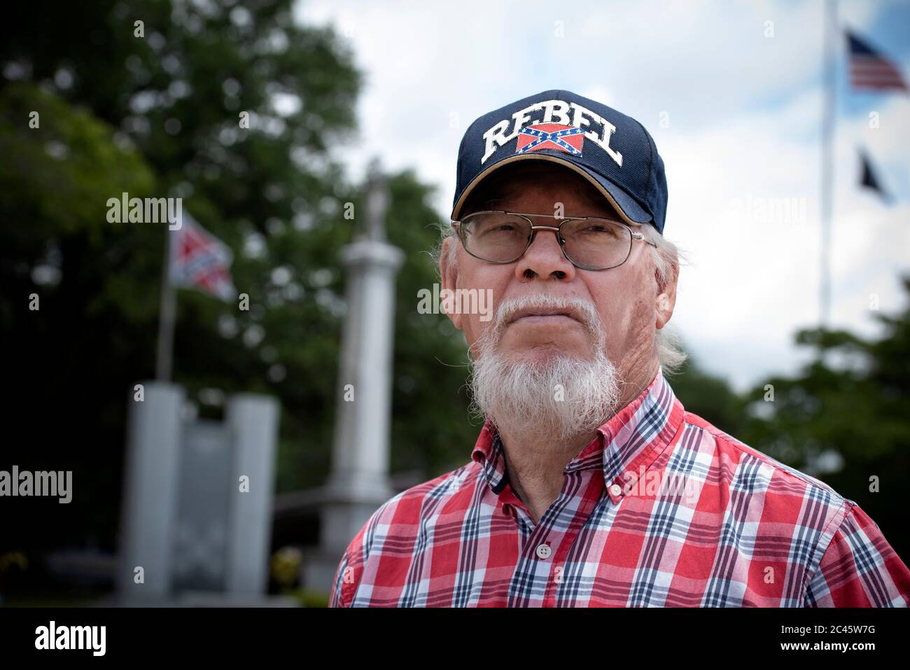 Eastman, GA, USA. Juni 2020. Anwohner versammeln sich vor dem Dodge County Courthouse, um gegen die fortgesetzte Existenz eines hohen Monuments eines konföderierten Soldaten zu protestieren, das laut Protestierenden rassistisch sei und schwarze Bewohner einschüchtern sollte, als es 1910 errichtet wurde. Im Bild: Mike Powell, 68, ein Mitglied der Söhne der konföderierten Veteranen, beobachtet den Protest vor der Sicherheit der Statue, die von der örtlichen Polizei gesichert wurde. Quelle: Robin Rayne/ZUMA Wire/Alamy Live News Stockfoto