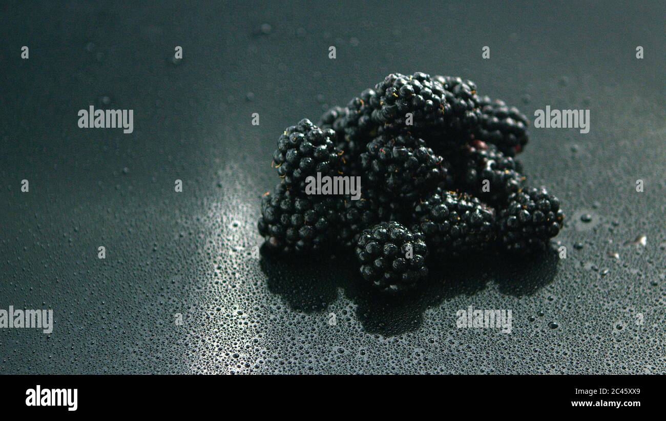 Stapel der glänzenden Brombeeren auf nasser Oberfläche Stockfoto