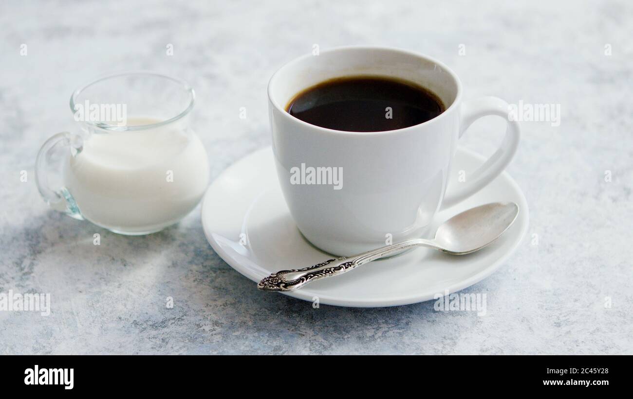 Tasse Kaffee und Krug Milch Stockfoto