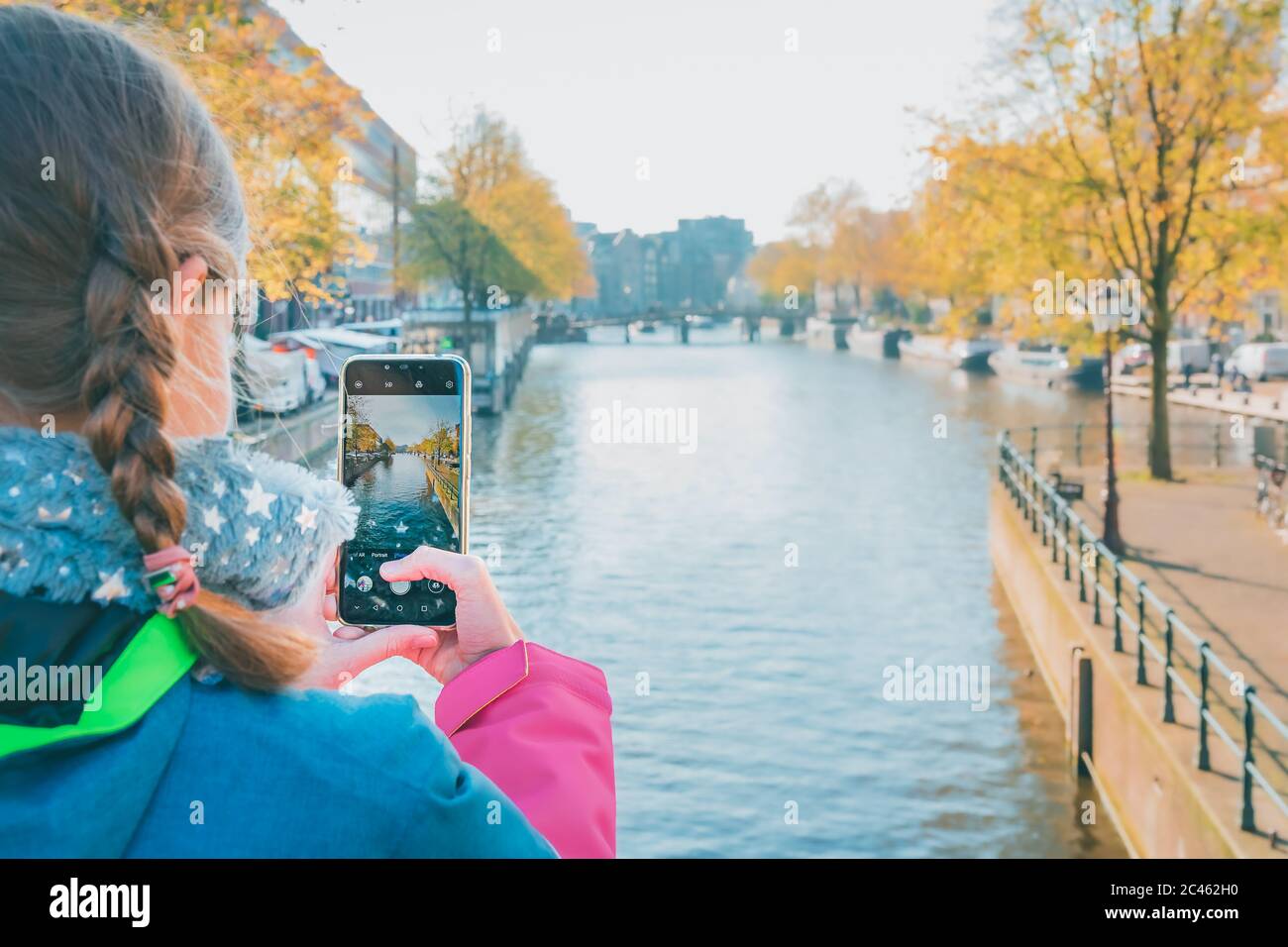 Junges Mädchen, das Foto mit dem Smartphone von Kanal in Amsterdam Stockfoto