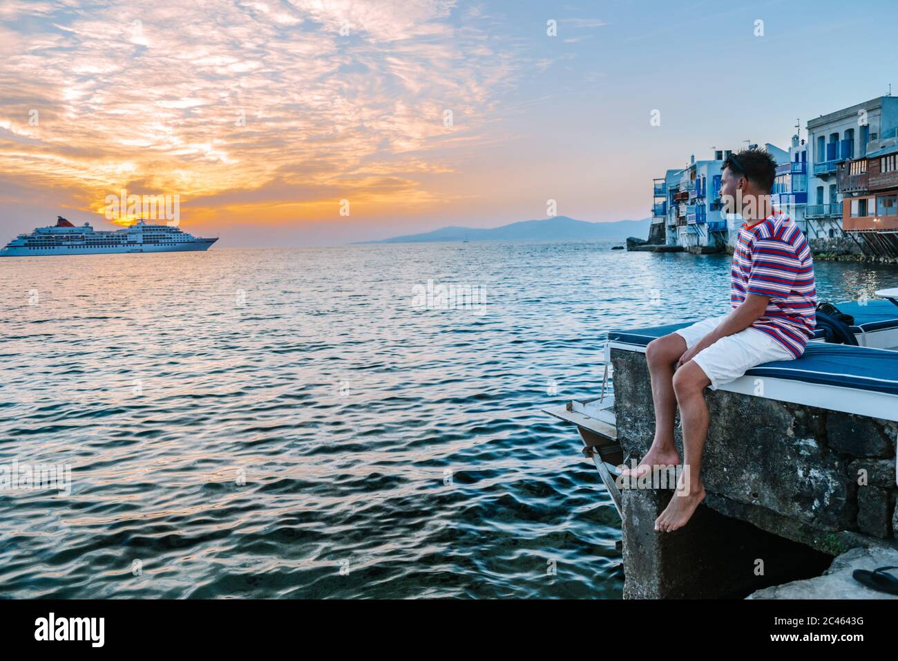 Ein junger Mann, der auf der griechischen Insel Mykonos Urlaub macht, Männer, die sich im kleinen dorf von venedig auf Mykonos Island entspannen Stockfoto