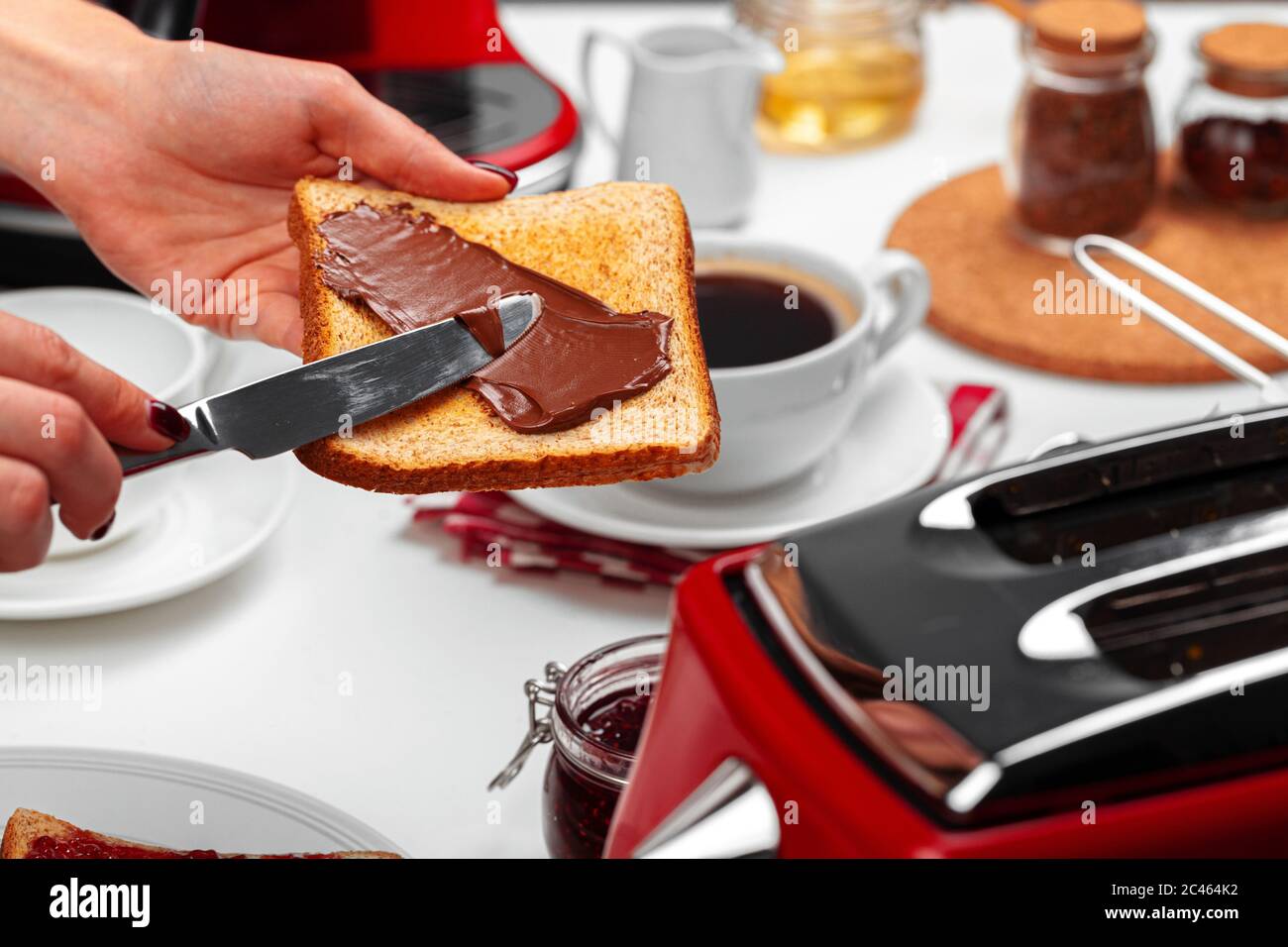 Weiblicher Handkochtoast mit Schokoladenpaste Stockfoto