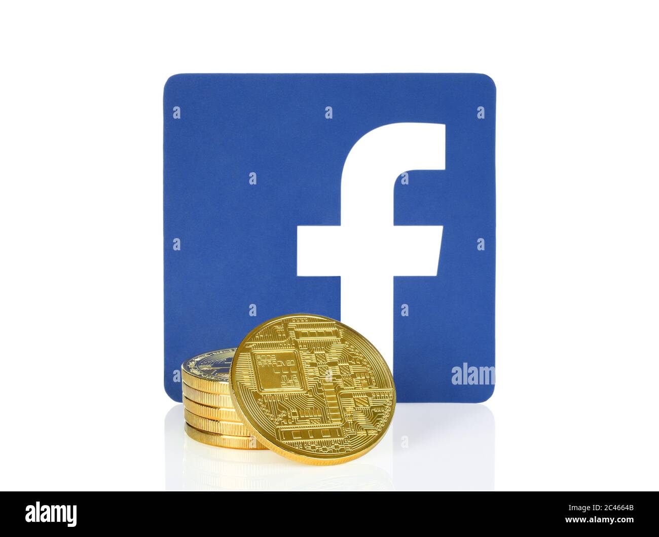 Kiew, Ukraine - 10. April 2019: Facebook-Symbol auf Papier gedruckt und mit Kryptowährungsmünzen platziert. Facebook entwickelt eine eigene Kryptowährung für remi Stockfoto
