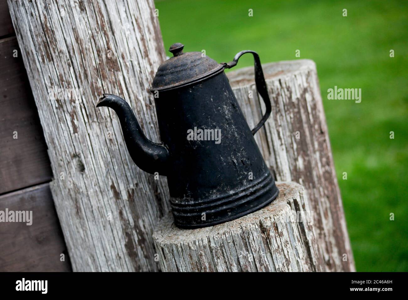 Alte geschwärzte Kaffeekanne für Show und Outdoor-Gebrauch Alte Telefonhölzer Stockfoto