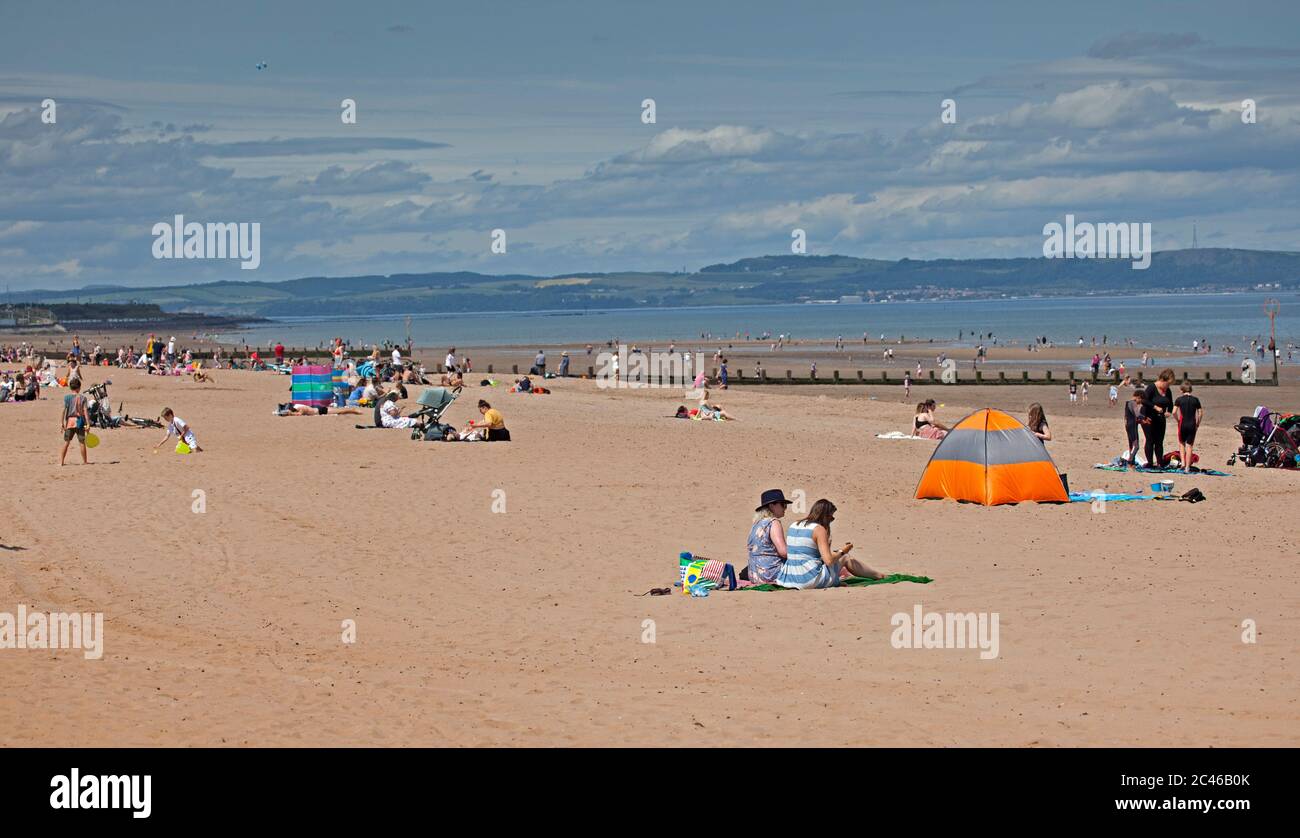 Portobello, Edinburgh, Schottland, Großbritannien. 24. Juni 2020. Das heiße Wetter brachte Familien raus, aber am Meer war nicht viel los, am Strand und an der Promenade gab es viel Platz, um sich in sozialer Distanz zu halten. Menschen auf verschiedenen Paddle Boards und Schlauchboote. Stockfoto