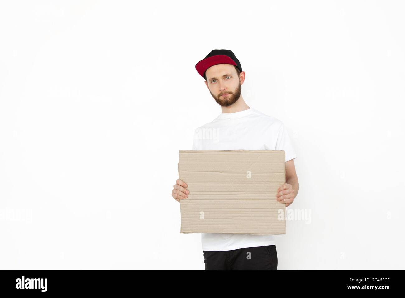 Junger Mann protestiert mit leerem Brett, Schild isoliert auf weißem Studio-Hintergrund. Aktivismus, aktive soziale Position, Protest, tatsächliche Probleme. Gegen Menschenrechte, Missbrauch, Wahlfreiheit. Stockfoto