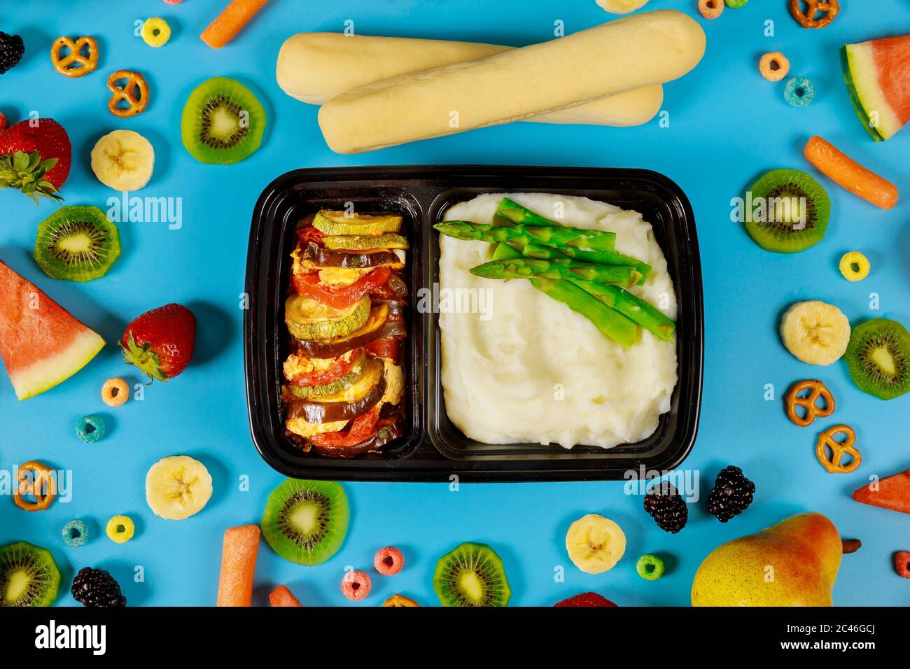 Leckeres Mittagessen in einem Behälter. Kartoffelpüree mit Spargel, Gemüse und Brotstock. Stockfoto