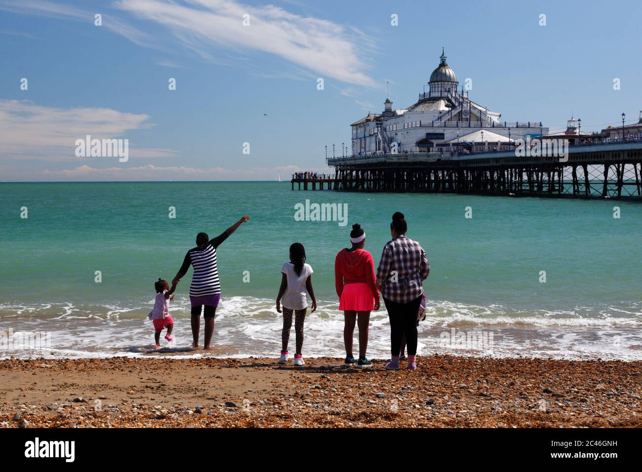Strand und Pier mit Familie am Wasser, Eastbourne, East Sussex, England, Großbritannien, Europa Stockfoto