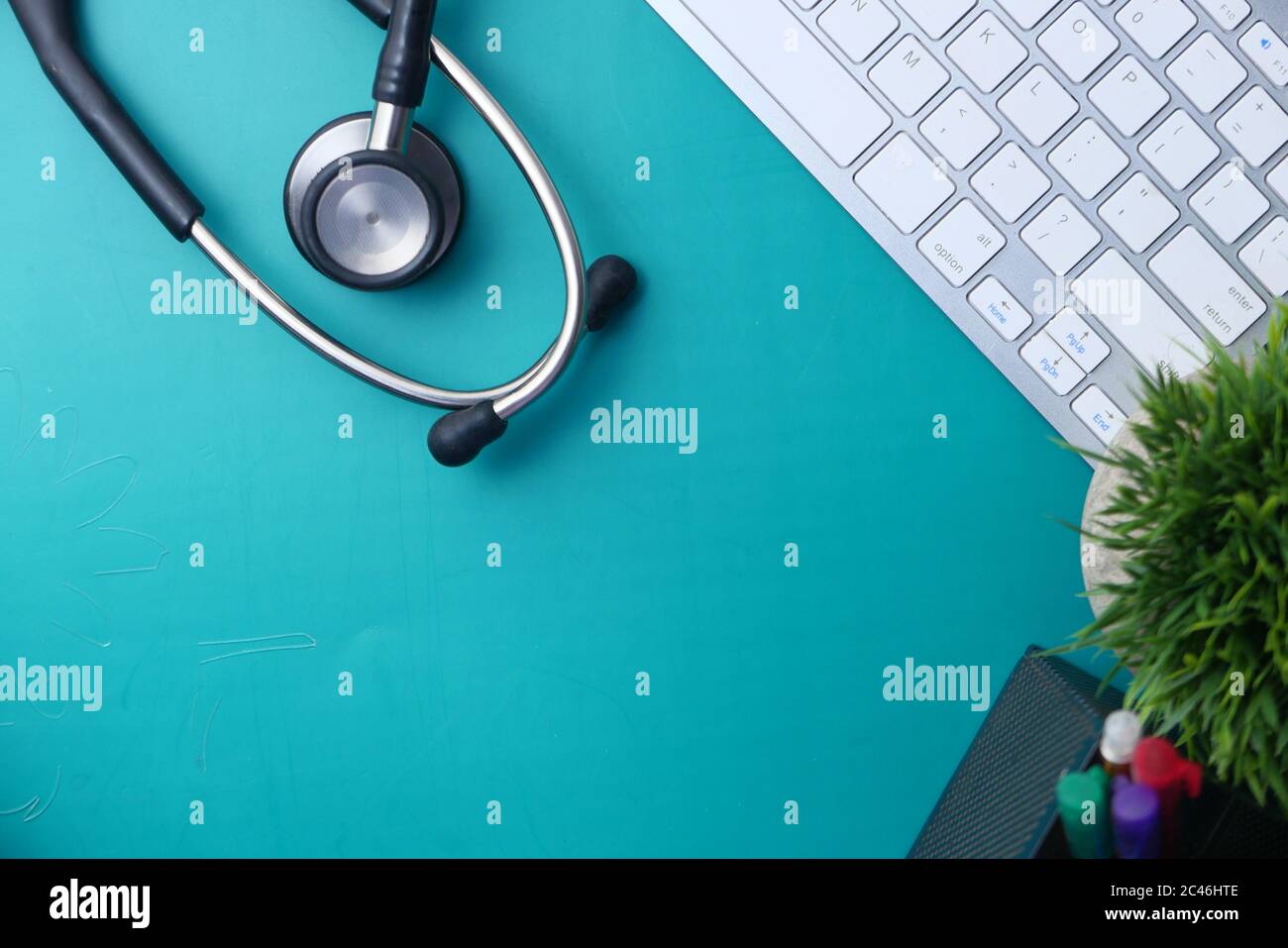 Medizinisches Stethoskop und Tastatur auf grünem Hintergrund Stockfoto