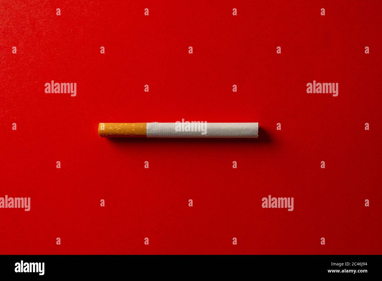 Zigarette auf rotem Hintergrund isoliert. Konzeptuelles Bild mit Platz für Text. Werbung Stil des Rauchens zu stoppen, verursacht Rauchen Krankheit, Gefahren von Stockfoto