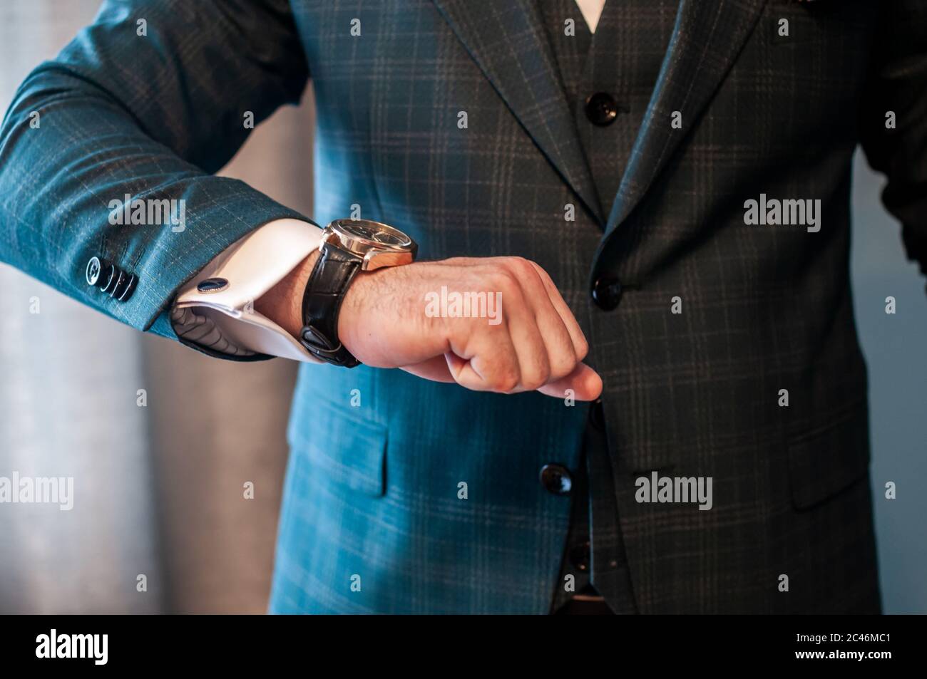 Der Bräutigam legt eine Uhr an sein Handgelenk Stockfoto