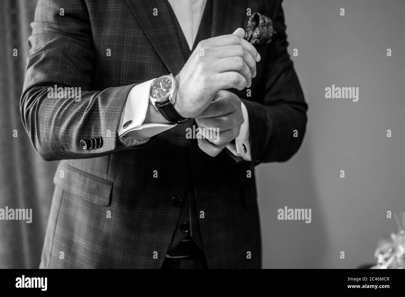 Der Bräutigam legt eine Uhr an sein Handgelenk Stockfoto