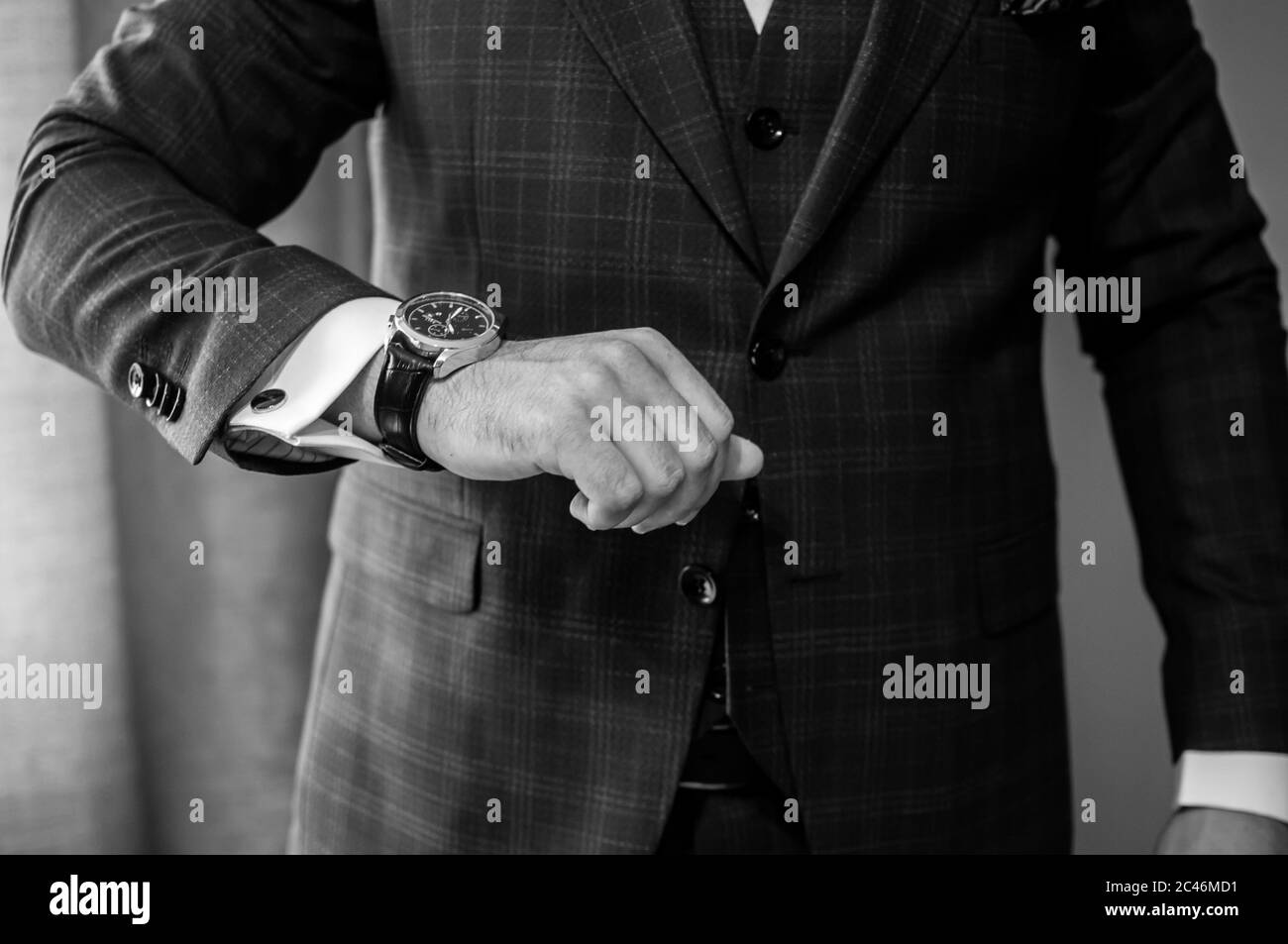 Der Bräutigam legt eine Uhr an sein Handgelenk Stockfoto