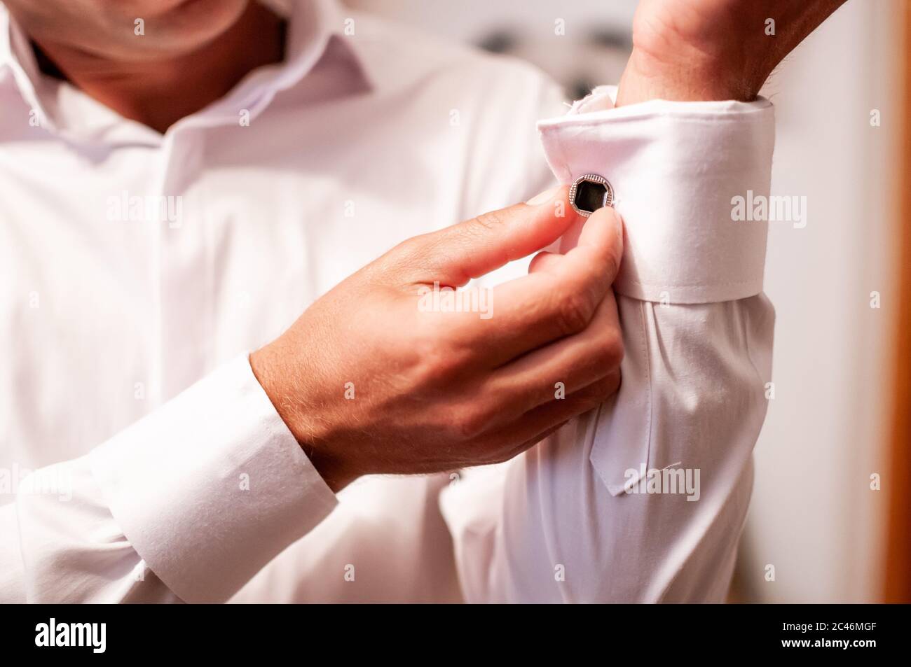 Der Bräutigam legt eine Uhr an sein Handgelenk Stockfoto