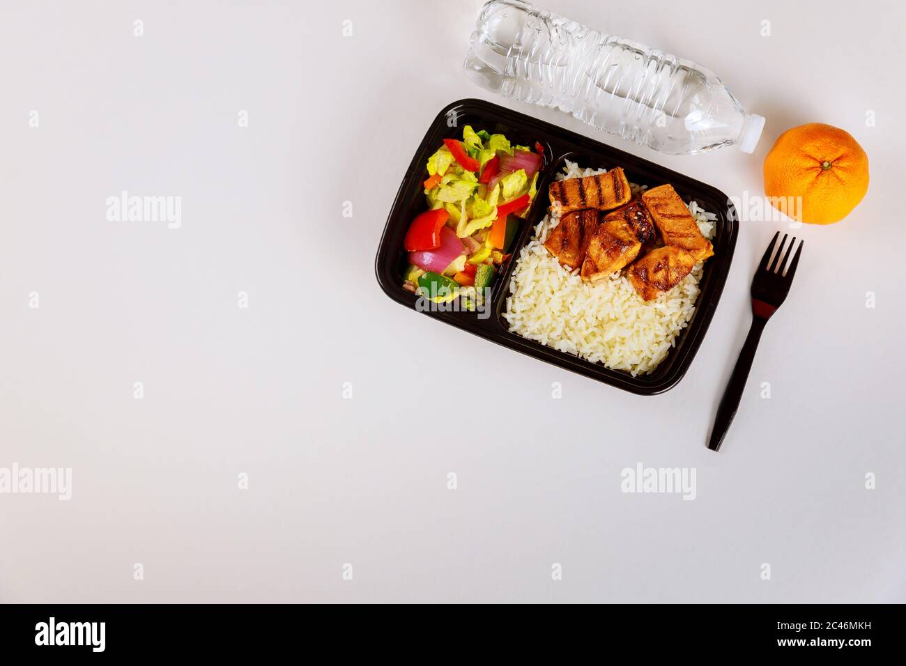 Fertiggerichte auf einem Behälter mit Gabel, Getränk und Orange zu essen. Stockfoto