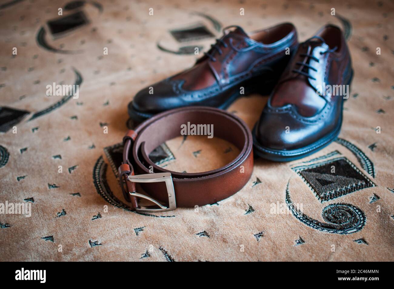 Herrenschuhe und brauner Gürtel auf dem Teppich Stockfoto