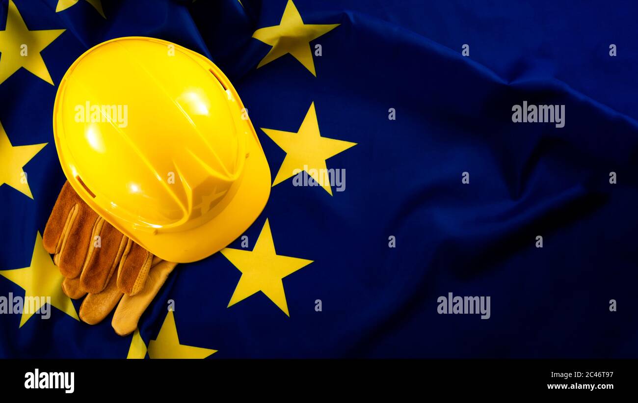Europäische Beschäftigung in der Bauindustrie Schwerindustrie, Labor Day und Industriearbeitskonzept mit Nahaufnahme auf einem gelben Hut und Schutzhandschuhe auf der Stockfoto