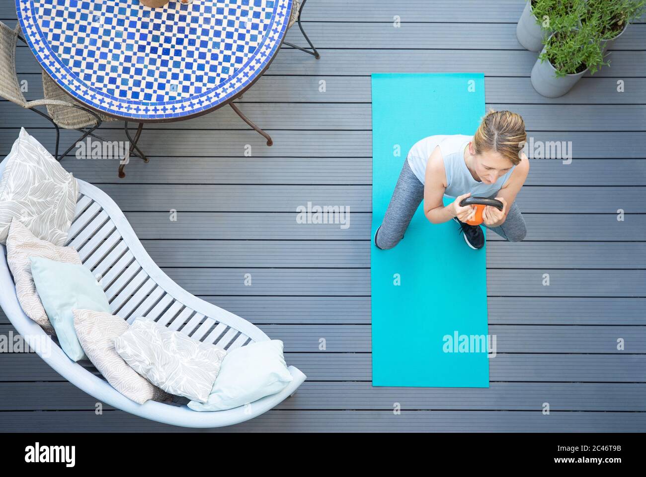 Overhead-Ansicht Der Gesunden Reifen Frau Zu Hause Training Auf Deck Mit Kettle Bell Gewicht Stockfoto