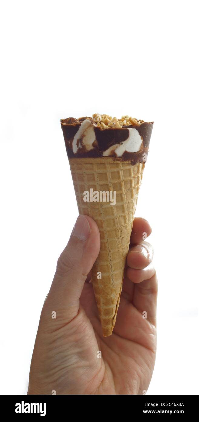 Mann Hand hält eine Schokolade bedeckt Vanille Eis-Kegel mit Erdnuss auf weißem Hintergrund Stockfoto