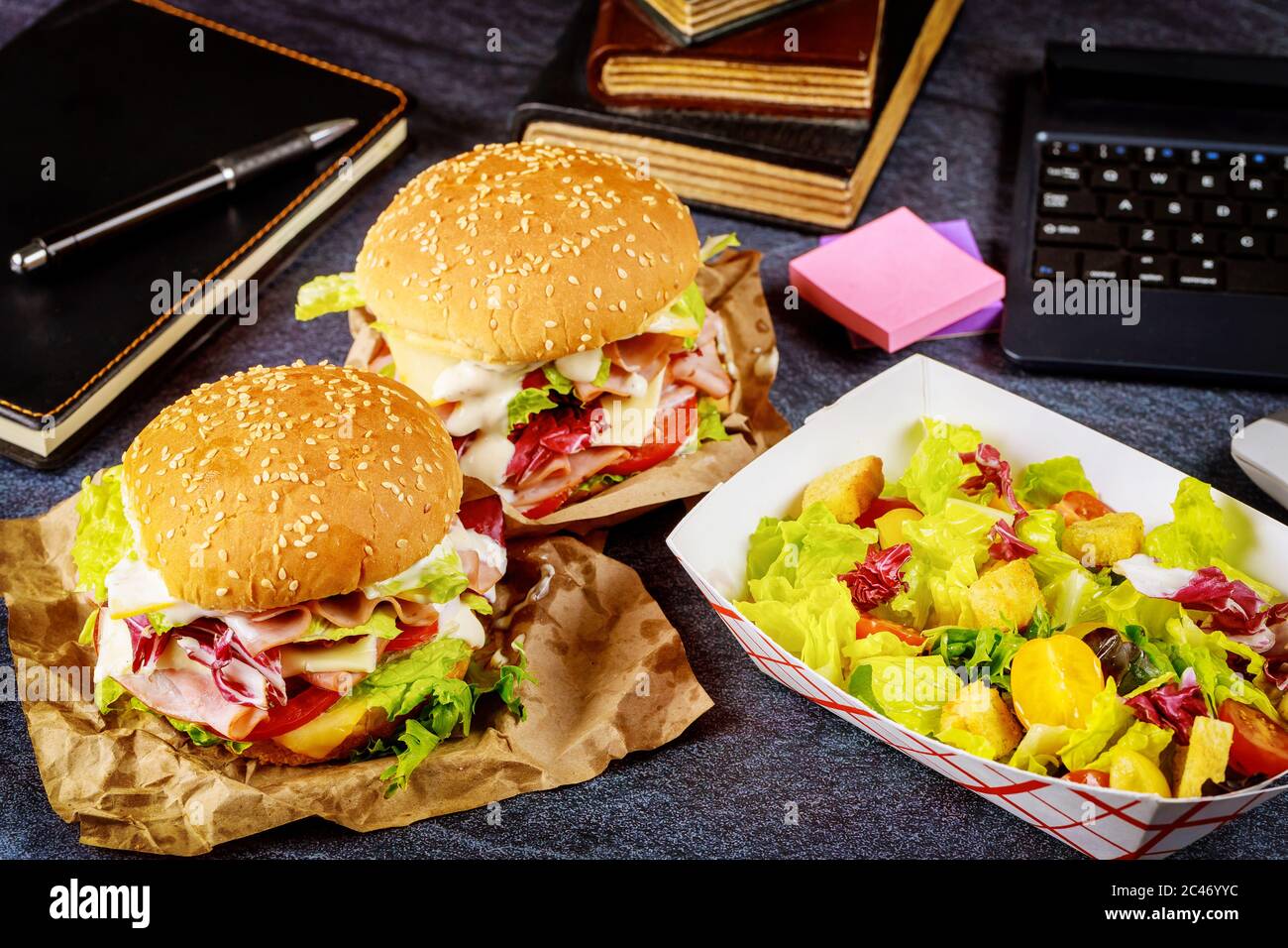 Schnellimbiss, Sandwich und Salat. Konzept „Work from Home“. Stockfoto