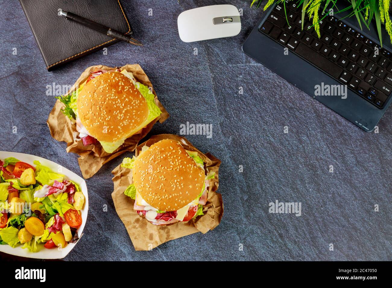 Schnellimbiss, Sandwich und Salat. Konzept „Work from Home“. Stockfoto