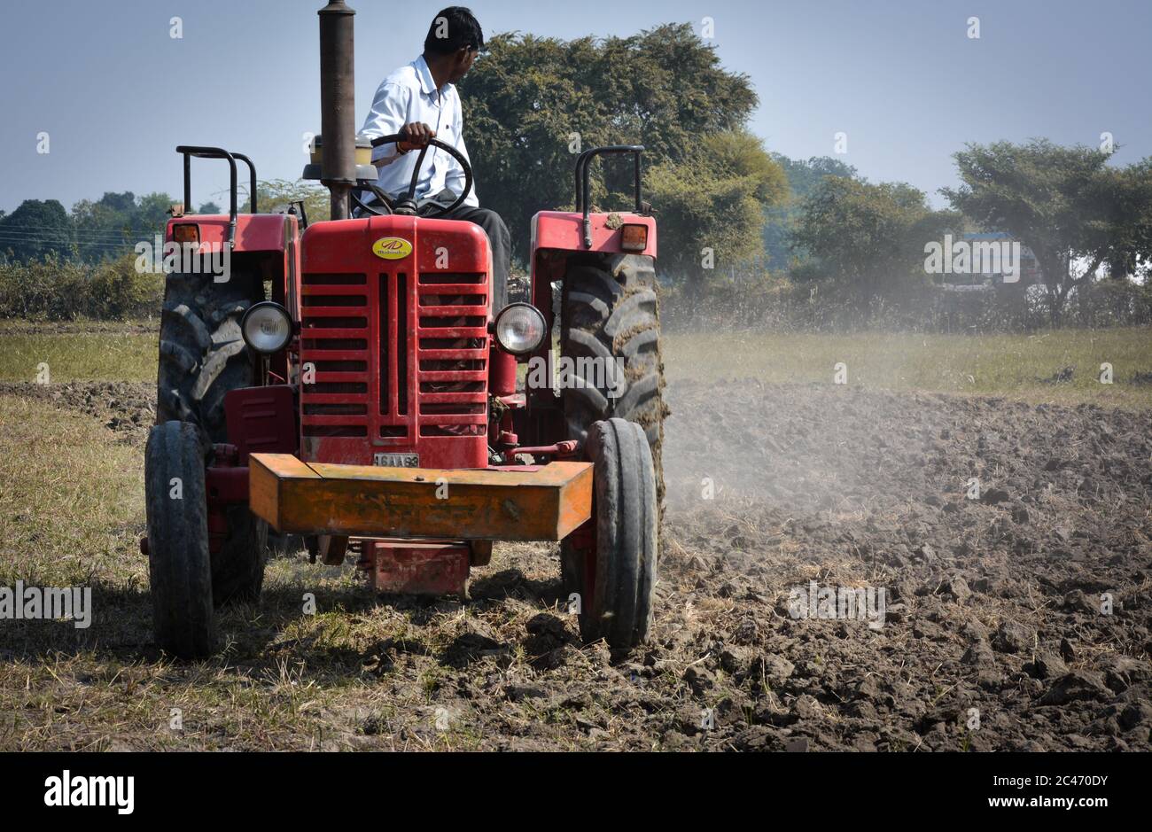 TIKAMGARH, MADHYA PRADESH, INDIEN - 10. NOVEMBER 2019: Indischer Bauer mit Traktor, der Land für die Aussaat mit Egge vorbereitet. Stockfoto