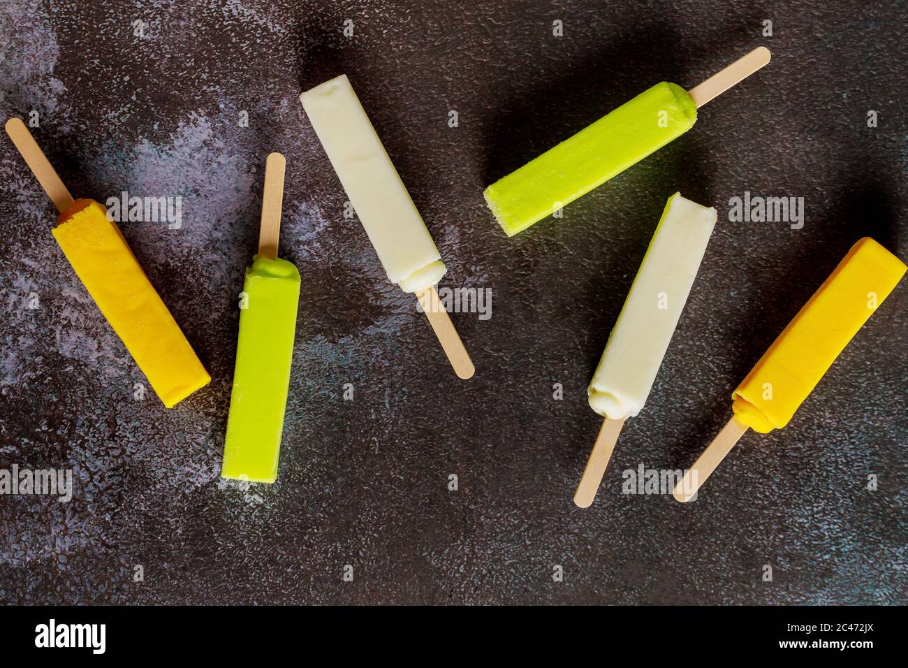 Sechs kalt sortierte Fruchtpopsicles auf dunklem Hintergrund. Stockfoto