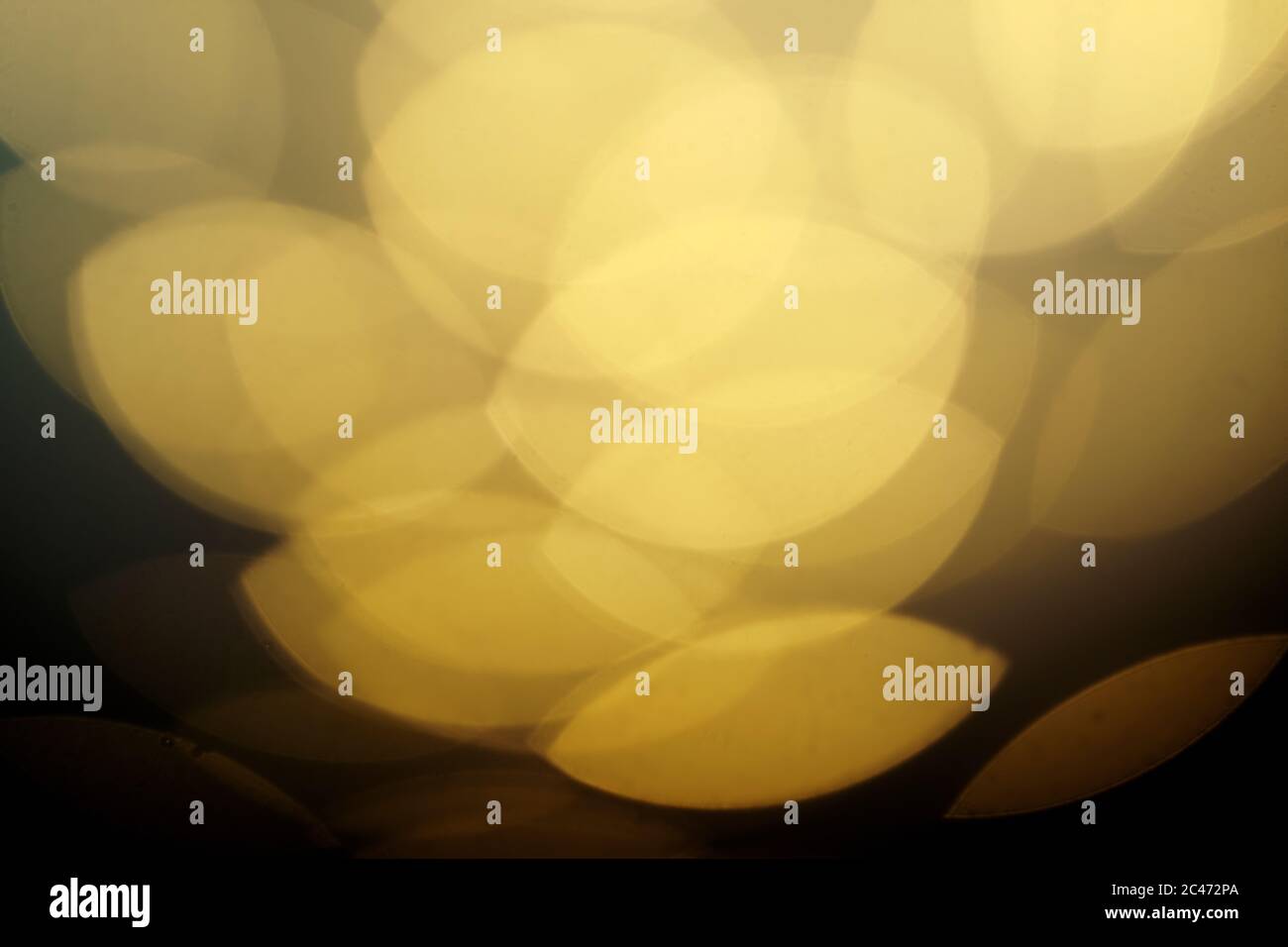 Abstrakter Hintergrund mit Bokeh-Effekten in hellgelben Tönen. Stockfoto