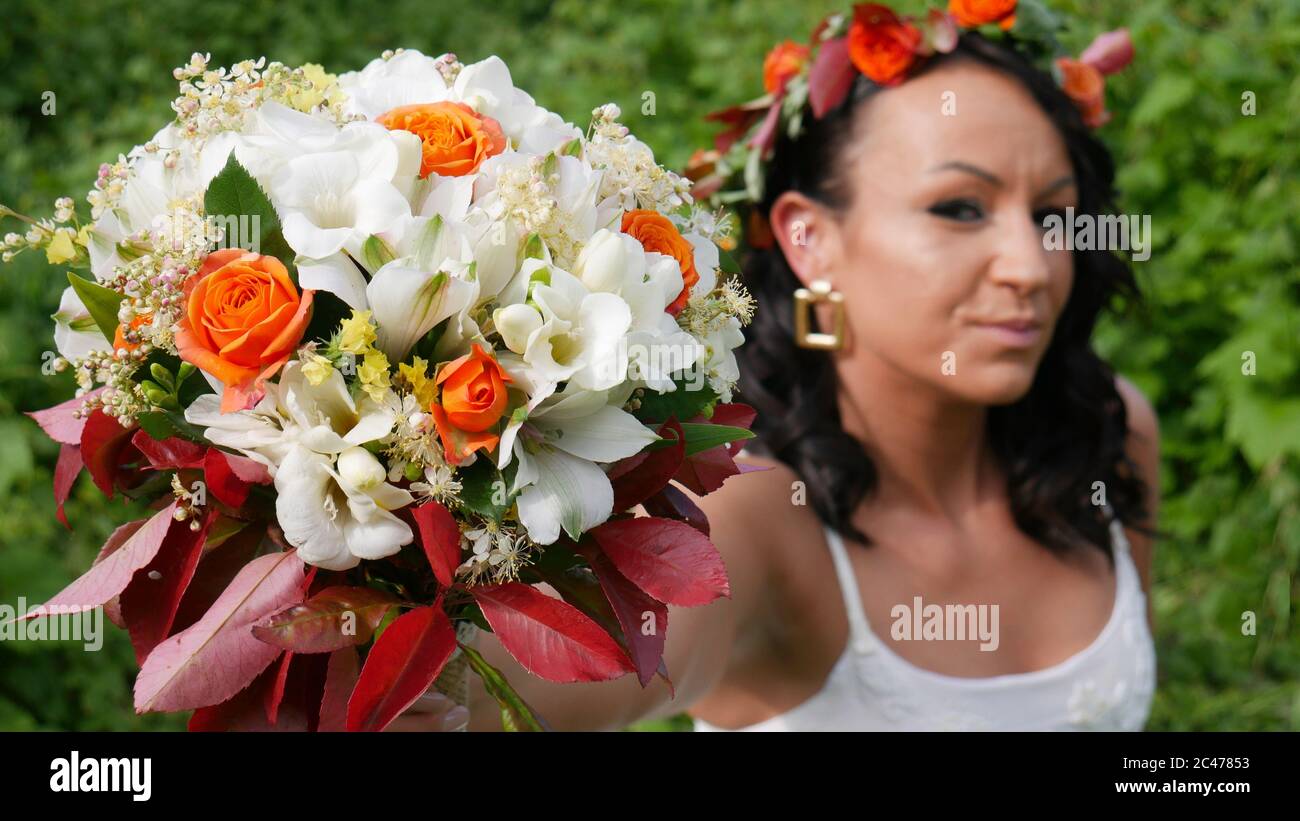 Ein schöner Strauß von weißen und orangen Blumen in den Händen der Braut. Stockfoto