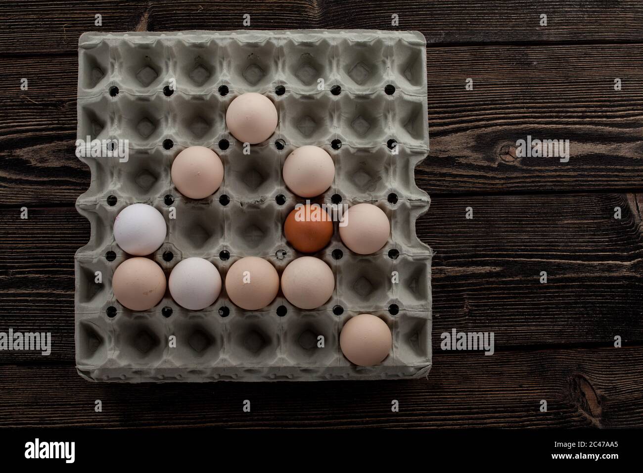 eierplaton. Mehrere weiße und gelbe Eier. osterdekoration. Eier auf Holzhintergrund. Rustikale Dekoration Stockfoto