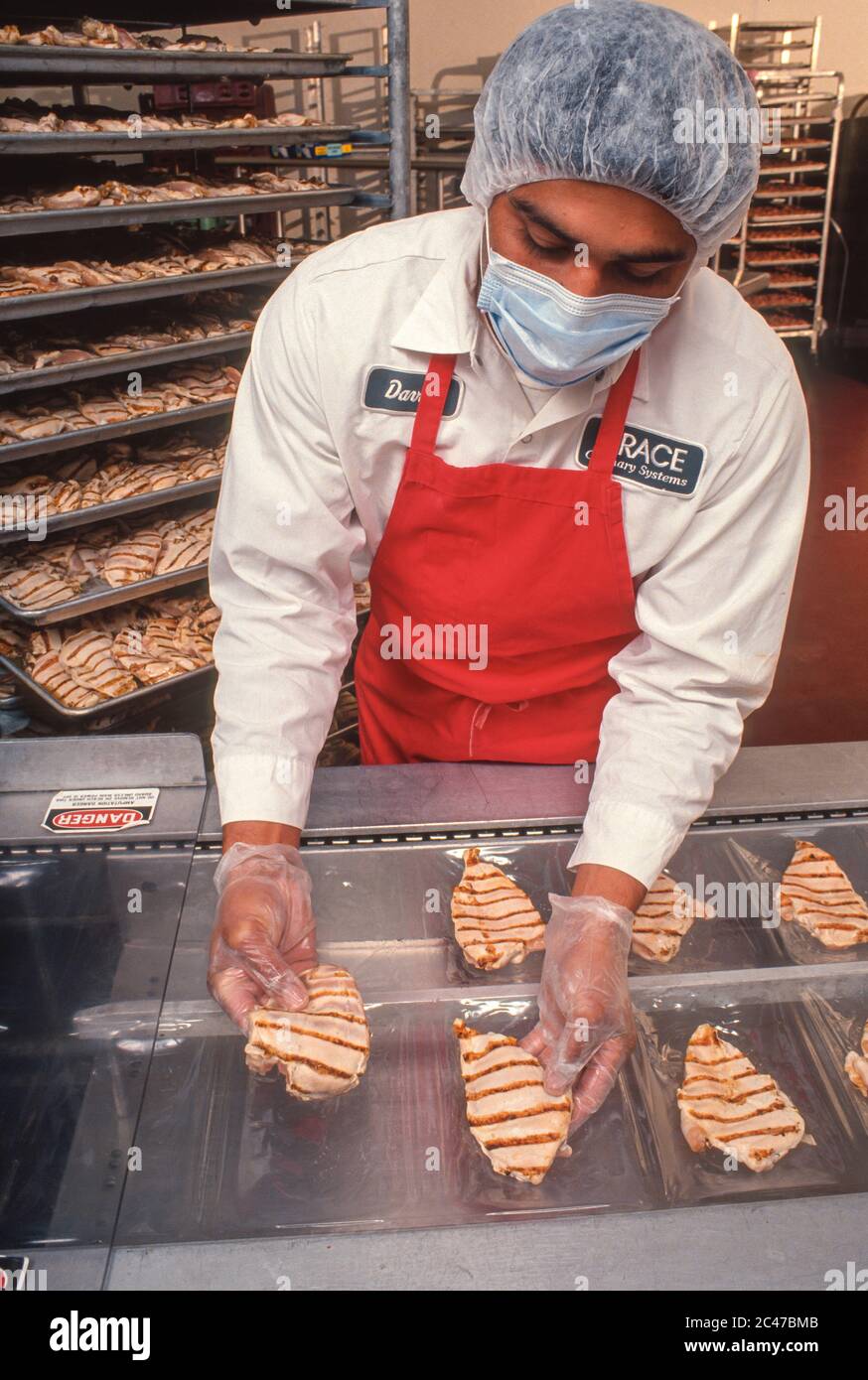 LAUREL, MARYLAND, USA, 8. OKTOBER 1991 - Worker bereitet vakuumverpacktes Sous Vide Huhn in Grace Culinary Systems vor. Stockfoto