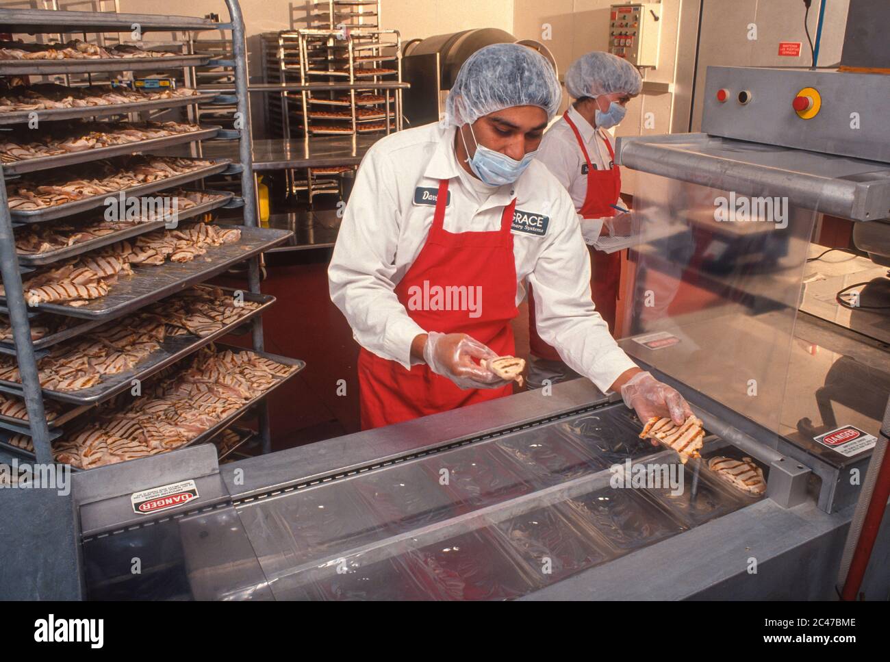 LAUREL, MARYLAND, USA, 8. OKTOBER 1991 - Worker bereitet vakuumverpacktes Sous Vide Huhn in Grace Culinary Systems vor. Stockfoto