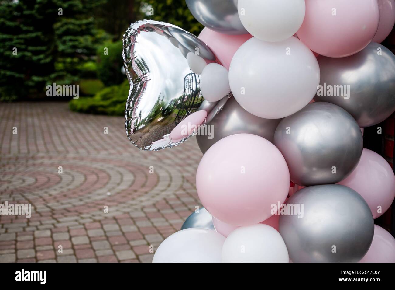 Pinkgraue und weiße aufblasbare Luftballons im Innenhof Stockfoto