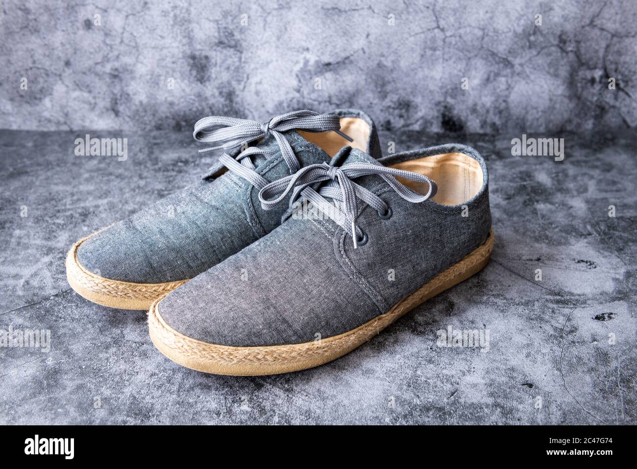 Ein Paar lässige Segeltuchschuhe in einem Betonhintergrund. Stockfoto