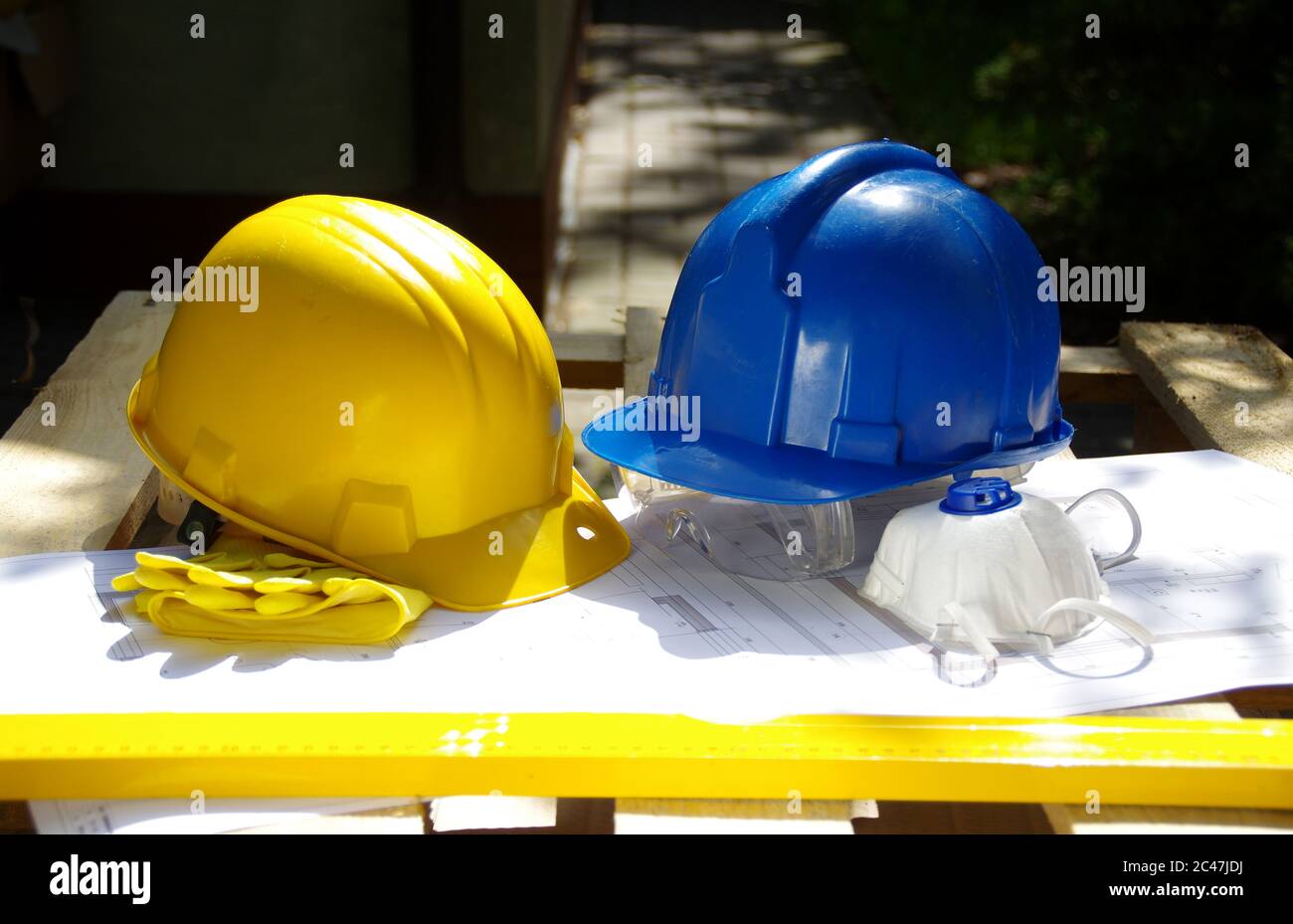 Gelber und blauer Schutzhelm. Persönliche Schutzausrüstung. Sicherheit auf der Baustelle. Stockfoto