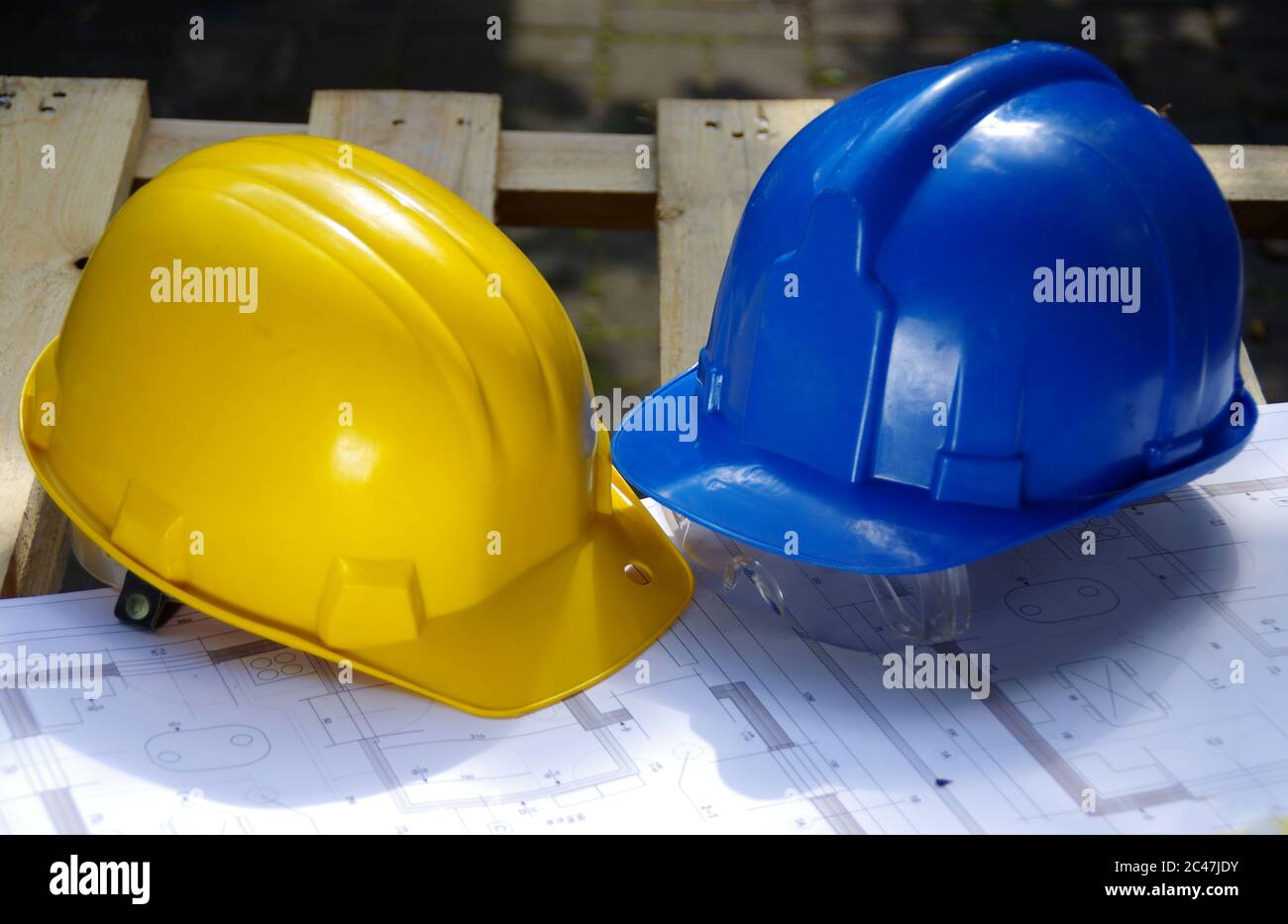 Gelber und blauer Schutzhelm. Persönliche Schutzausrüstung. Sicherheit auf der Baustelle. Stockfoto