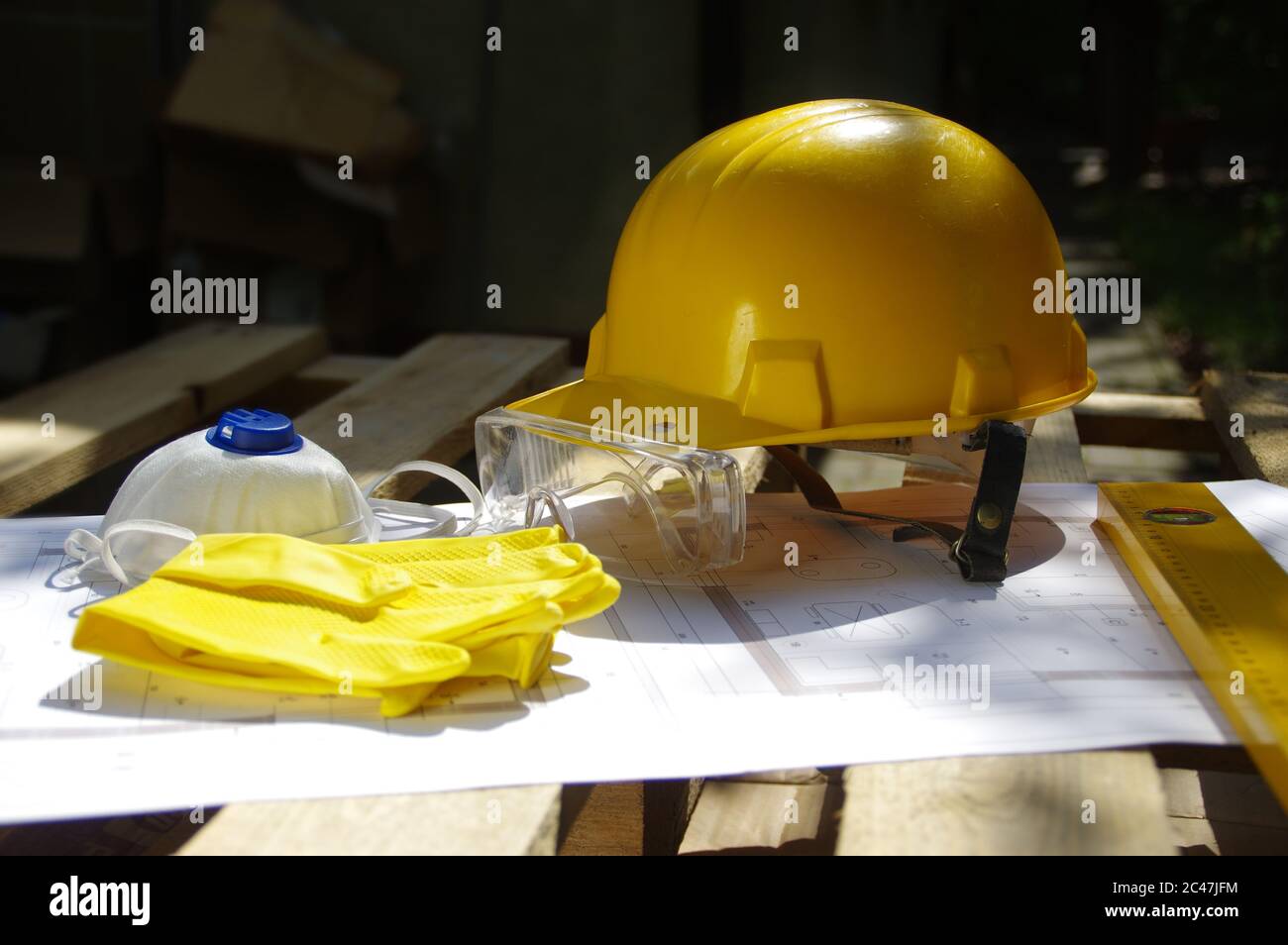 Helm, Schutzbrille, Maske und Handschuhe. Persönliche Schutzausrüstung auf der Baustelle. Schwerindustrie. Stockfoto