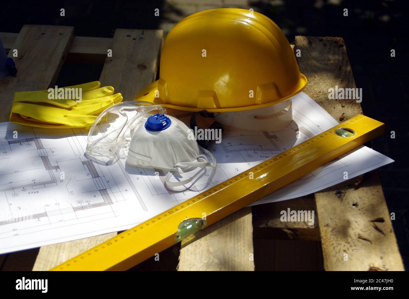 Helm, Schutzbrille, Maske und Handschuhe. Persönliche Schutzausrüstung auf der Baustelle. Schwerindustrie. Stockfoto