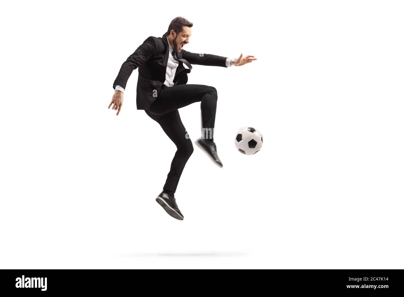 In voller Länge Profilaufnahme eines Mannes in einem schwarzen Anzug tritt einen Fußball isoliert auf weißem Hintergrund Stockfoto