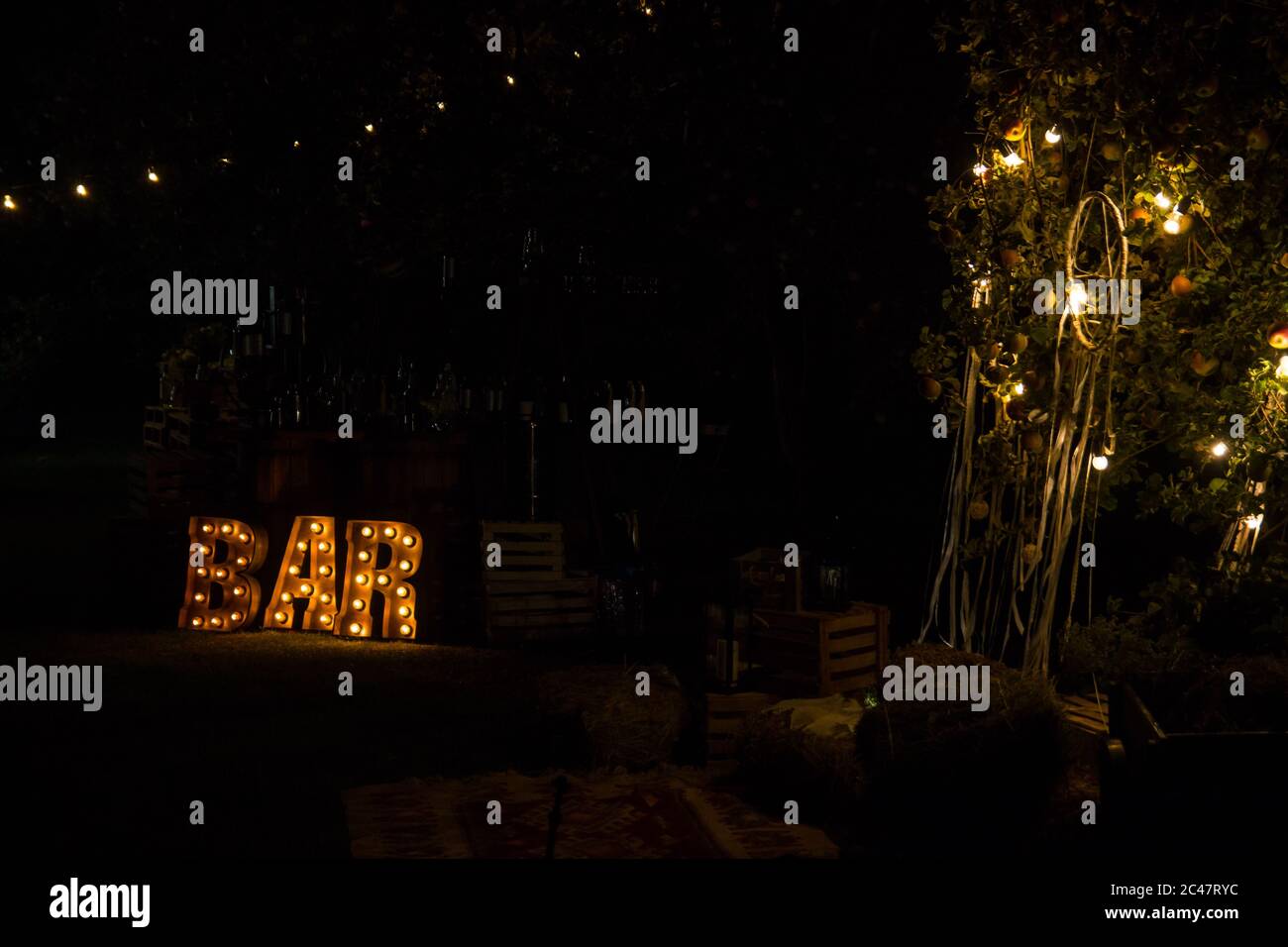 Große leuchtende Buchstaben in der Nähe der Bar. Gelbe Lampen. Stockfoto